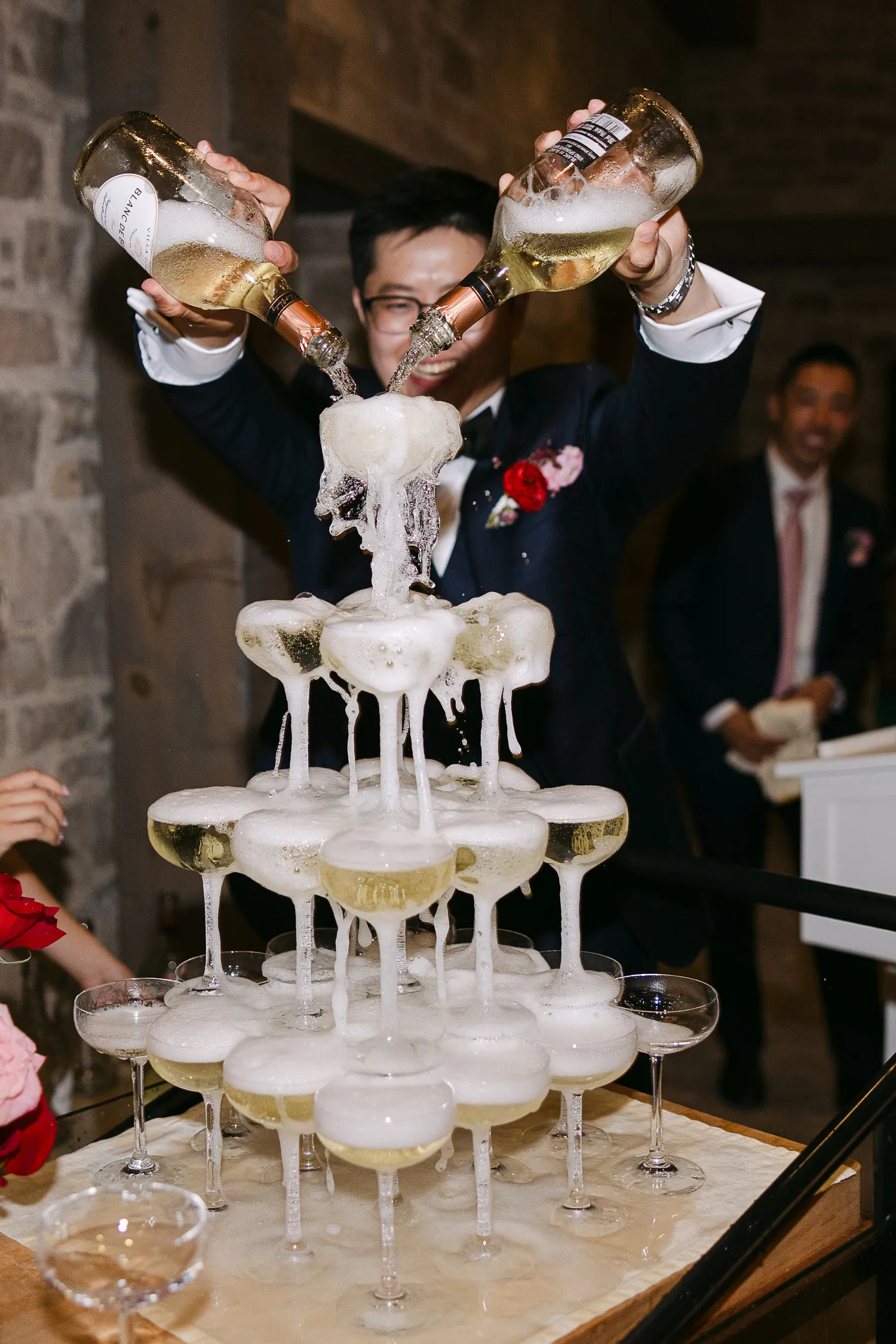 Groom pouring champagne during reception at Elora Mills