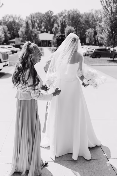 Bride with bridesmaid adjusting veil before ceremony at vineyard wedding Niagara-on-the-Lake