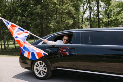 Wedding party celebrating with flags from limousine at Chateau des Charmes wedding
