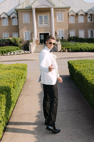 Château des Charmes wedding photographer capturing groom portrait at estate entrance