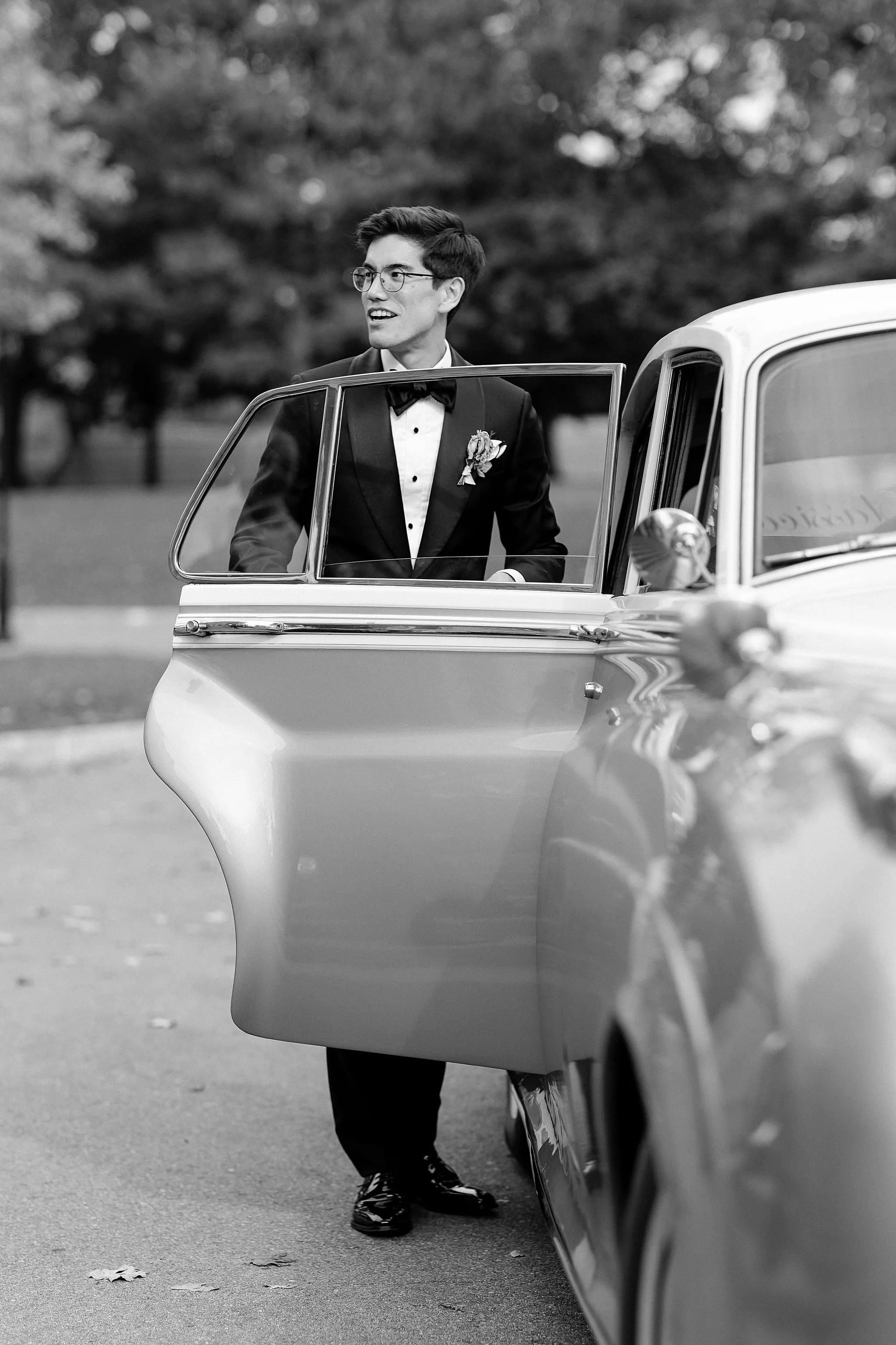 Groom posing next to the car