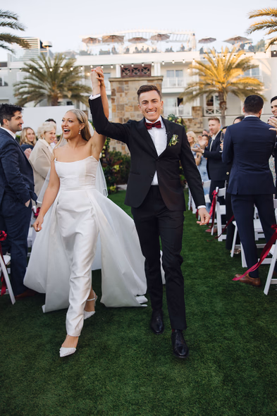 Joyful newlyweds walking down the aisle at Lido House Newport Beach