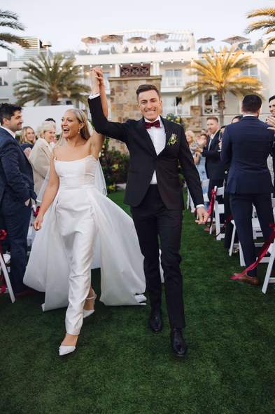 Joyful newlyweds walking down the aisle at Lido House Newport Beach