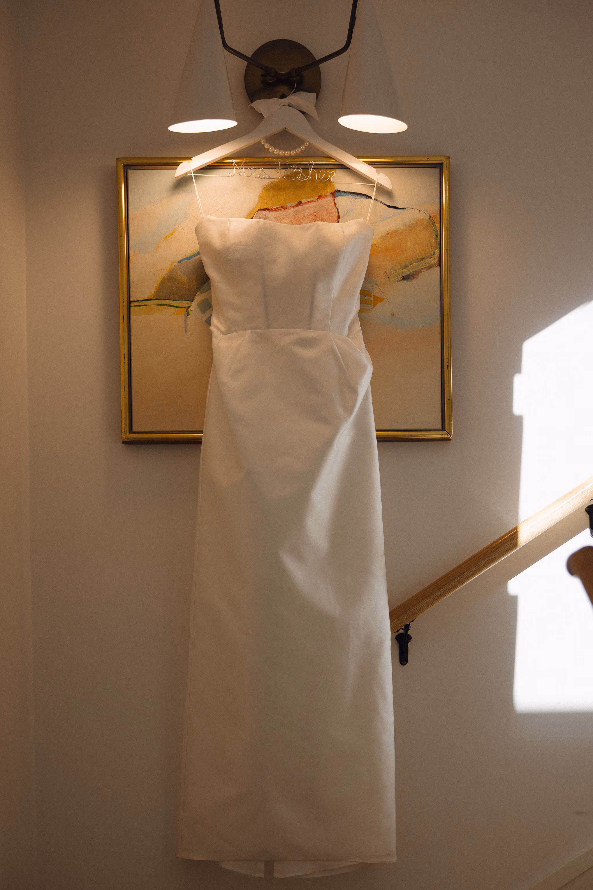 Simple and elegant wedding dress hanging in Lido House hallway