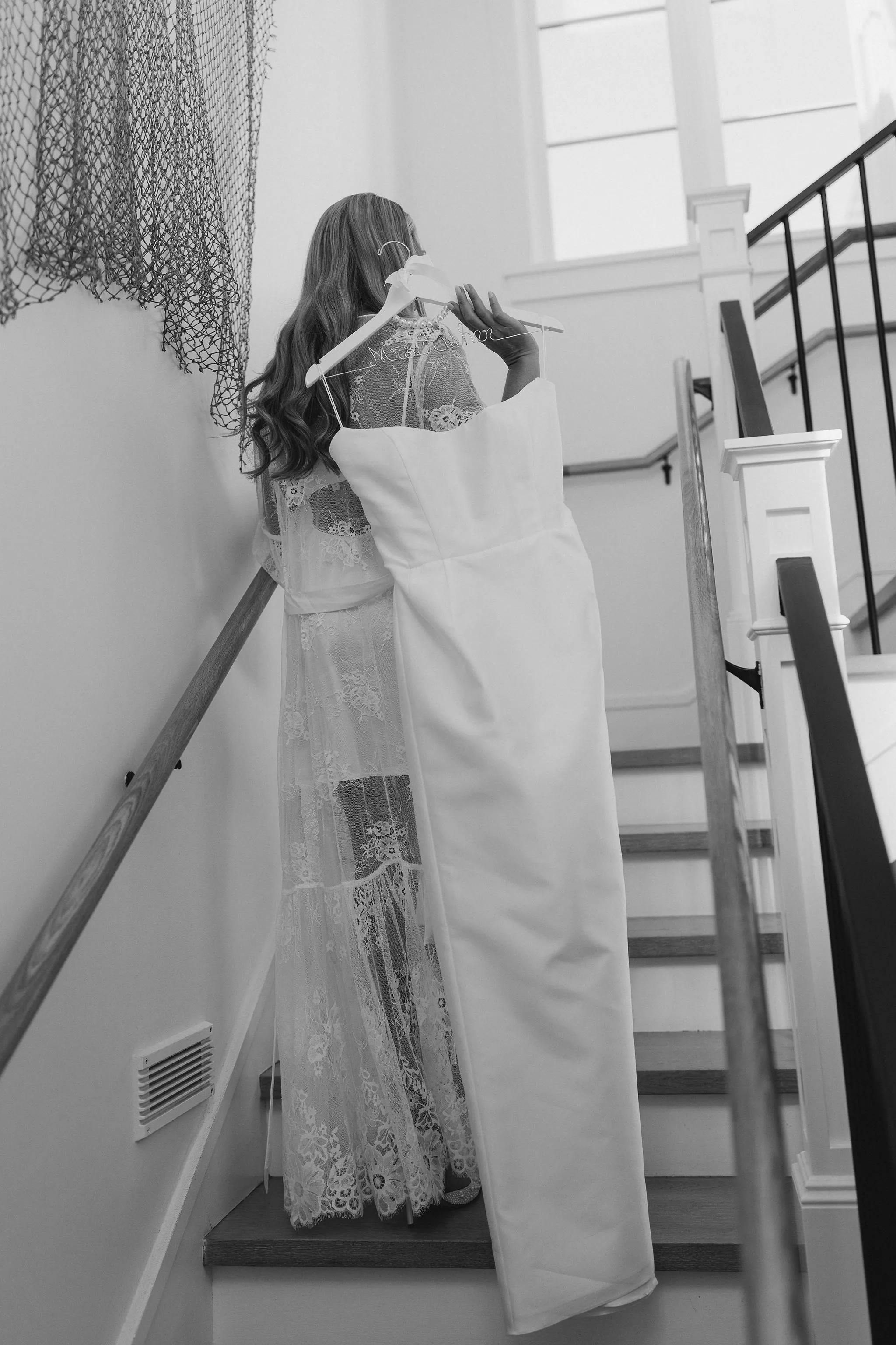 Bride adjusting wedding dress on staircase at Lido House