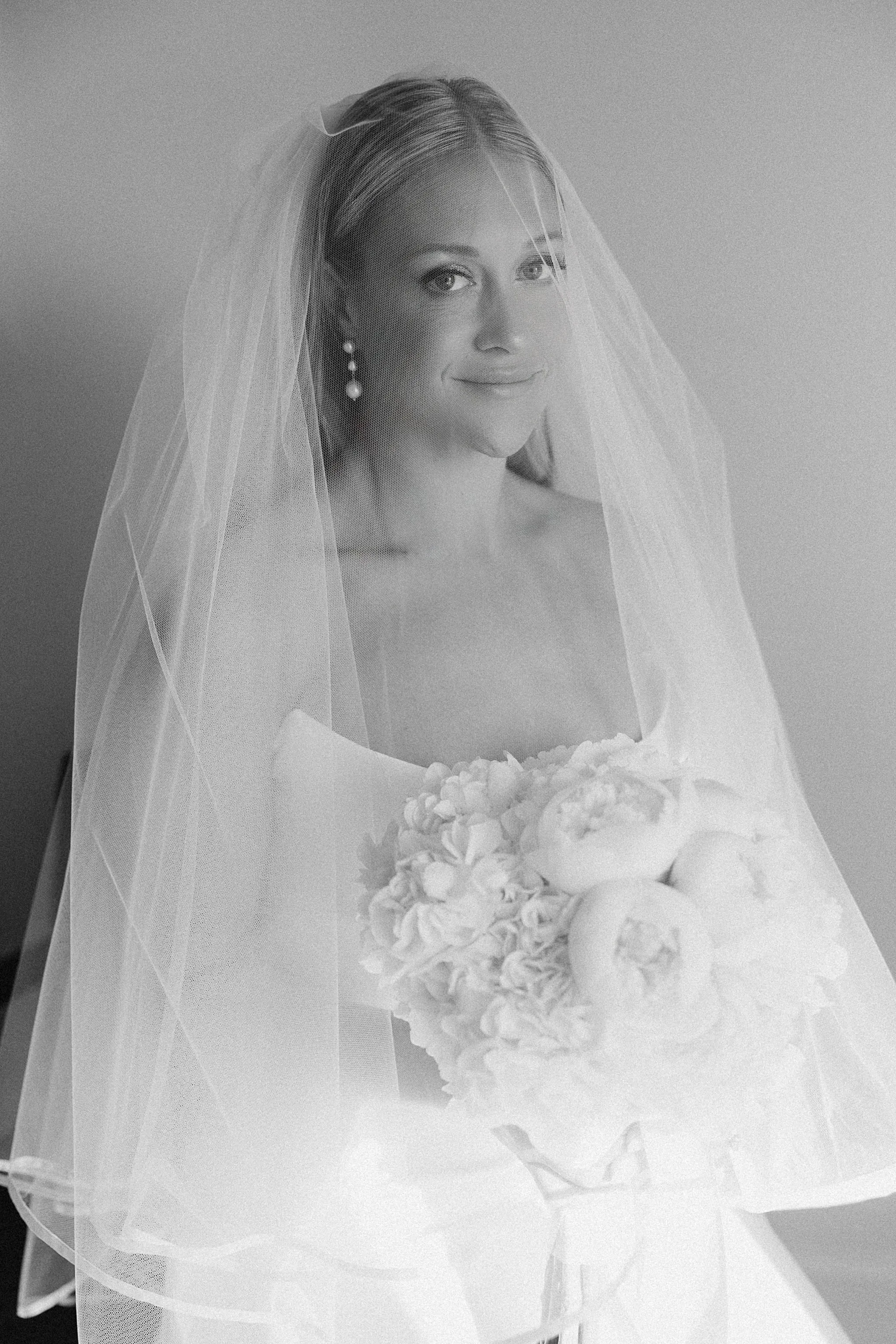 Bride holding bouquet with a serene expression at Lido House