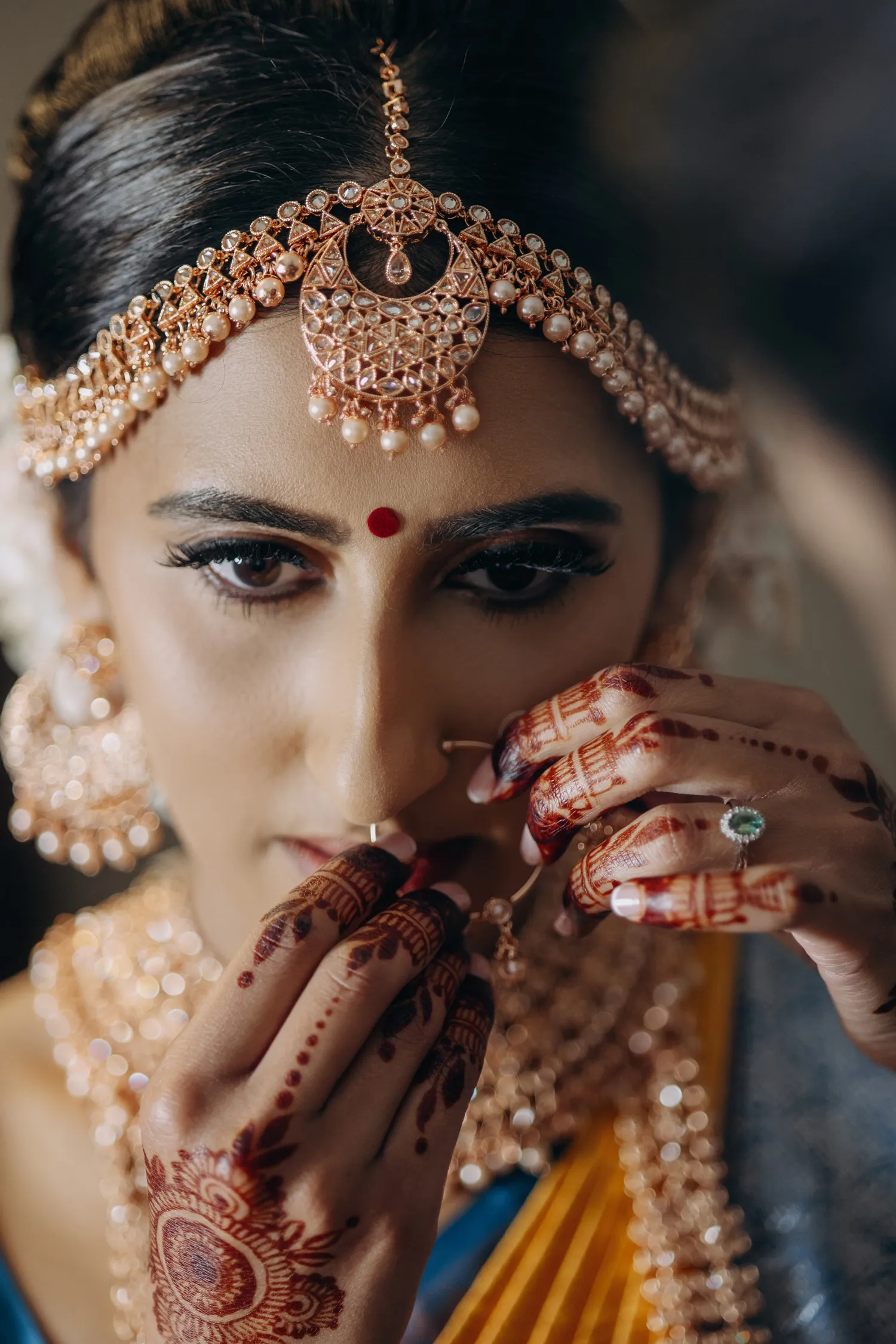 Close-up of Tamil Hindu bride adjusting nose ring before wedding ceremony in Madison Greenhouse