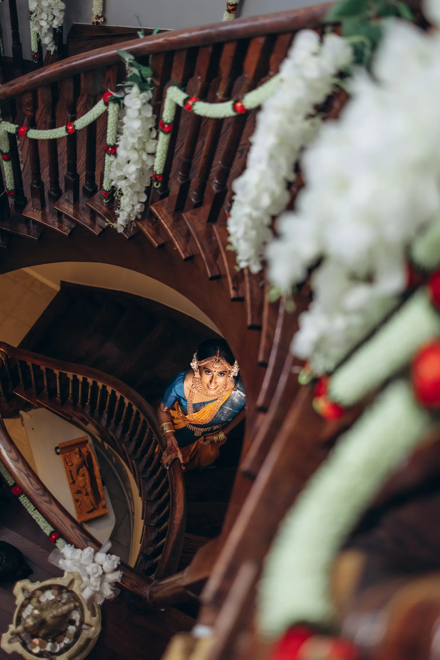 Bride walking down staircase at Tamil wedding venue in Toronto decorated with jasmine garlands