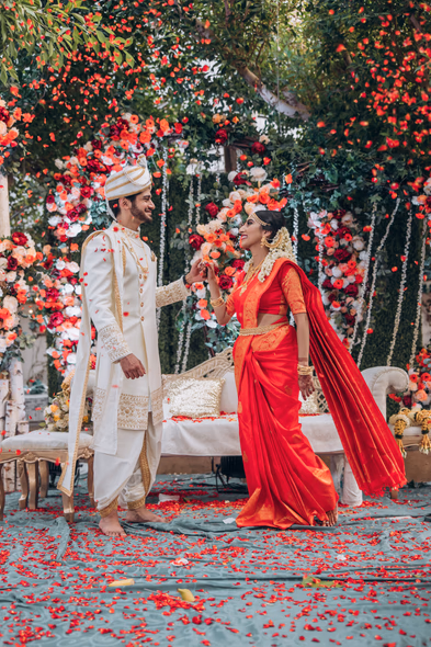 Bride and groom exchange garlands during Tamil outdoor wedding at Madison Greenhouse