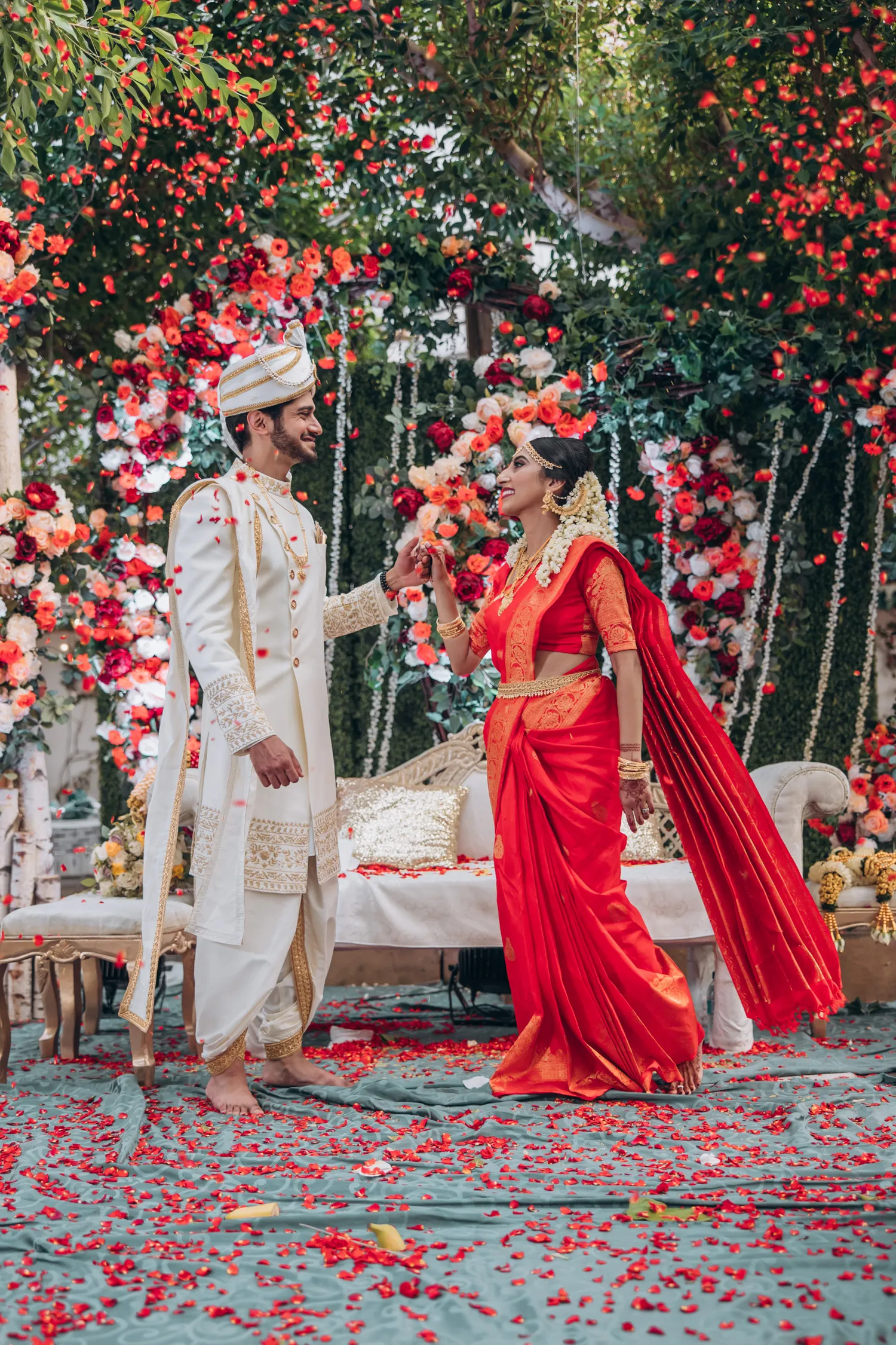 Bride and groom exchange garlands during Tamil outdoor wedding at Madison Greenhouse