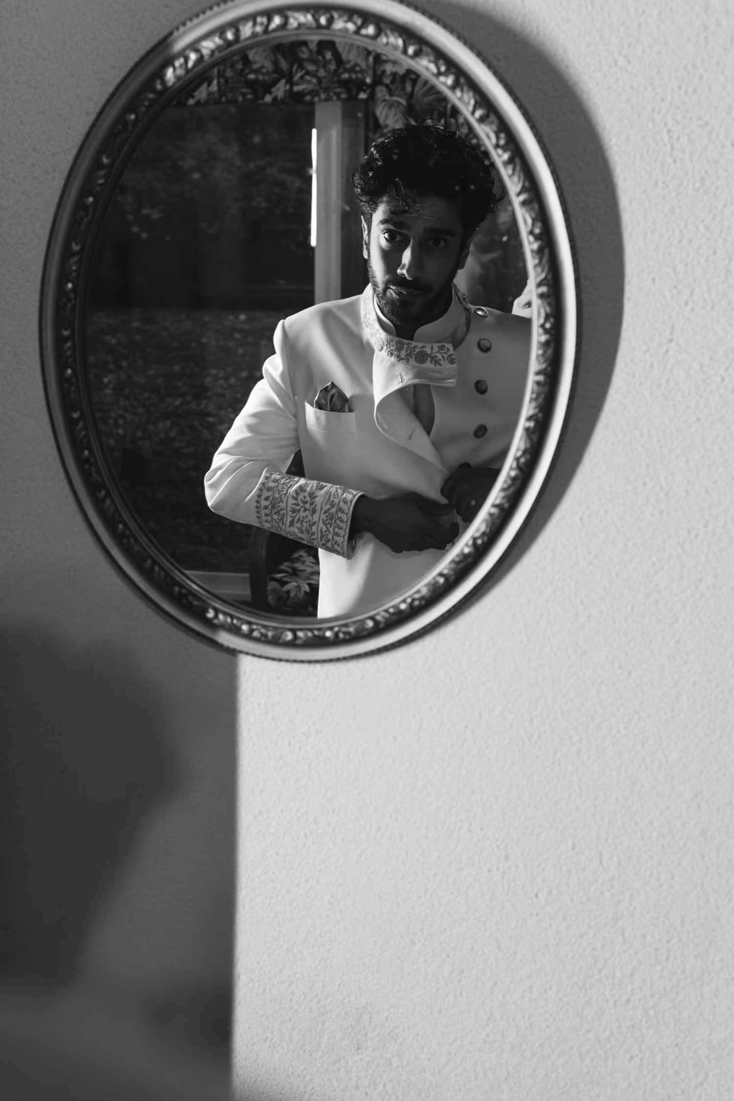 Groom reflection in mirror while getting ready for Tamil wedding in greenhouse venue