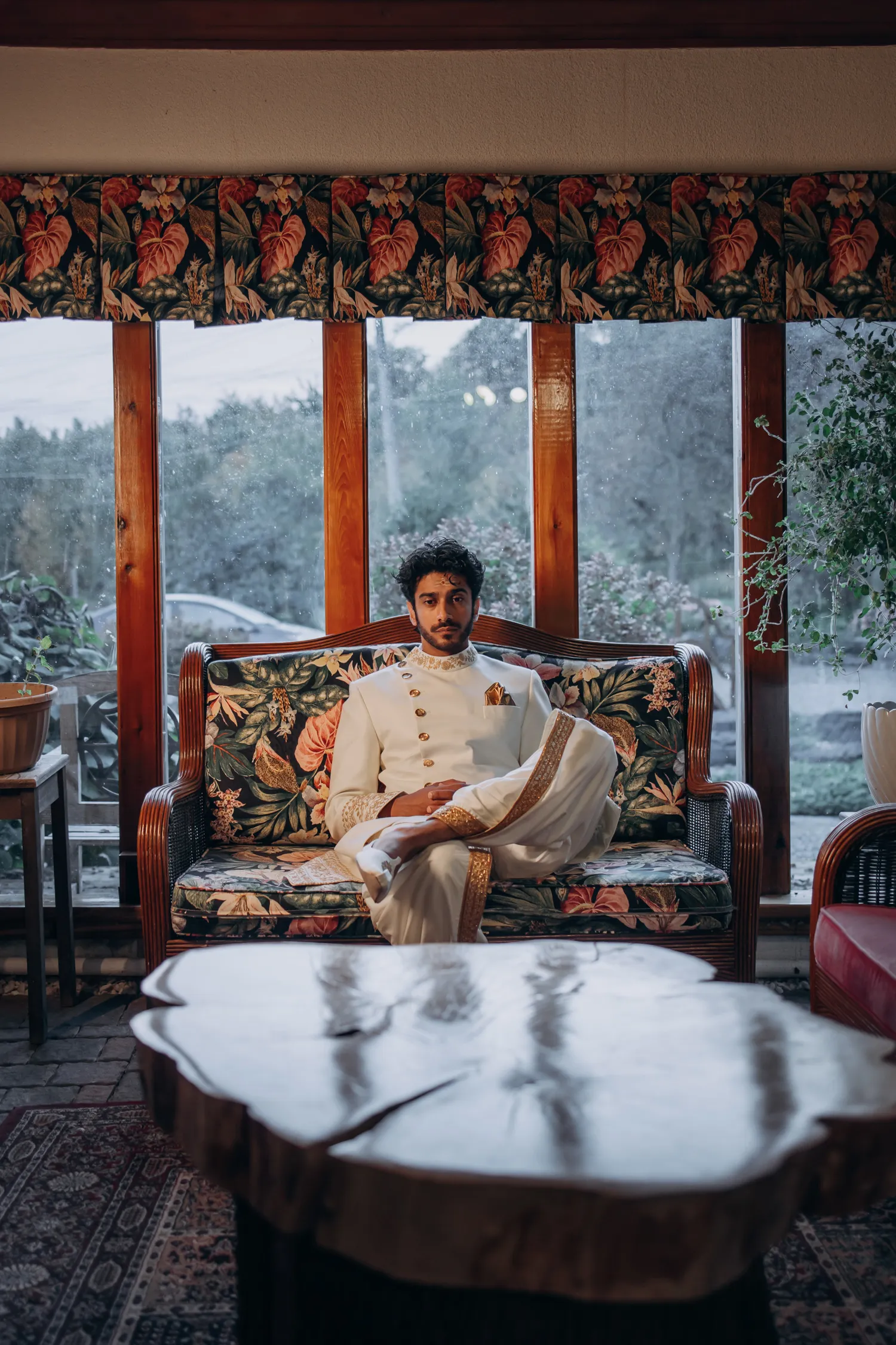 Groom sitting indoors in traditional attire before Madison Greenhouse Tamil wedding