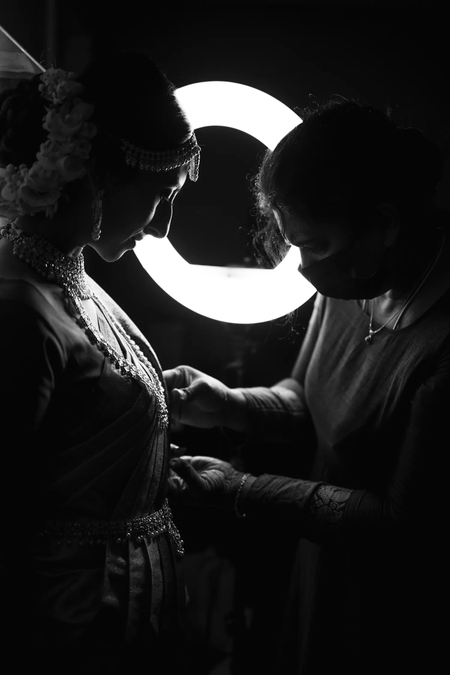 Getting ready moment captured in silhouette lighting at Tamil Hindu wedding