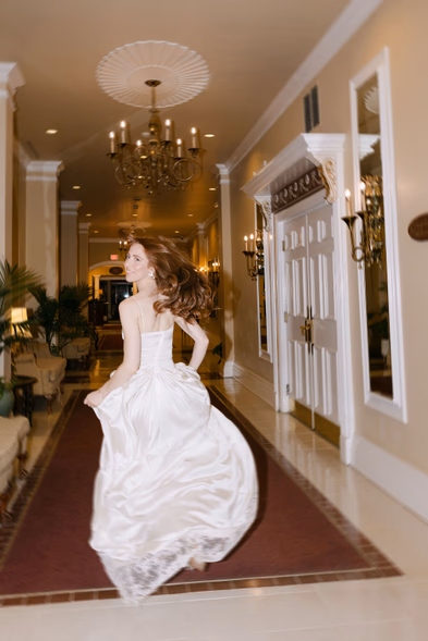 bride running through hallway candid reception moment Queen’s Landing hotel wedding