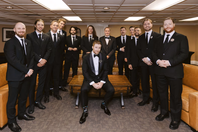 groom with groomsmen group portrait formal suits wedding day preparation