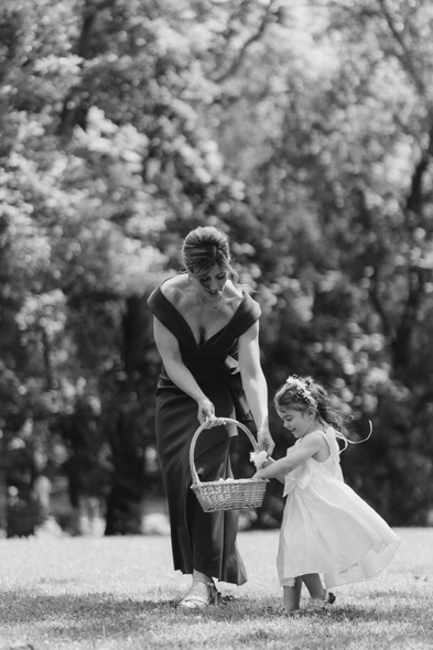 black and white candid flower girl with mother emotional moment outdoor wedding