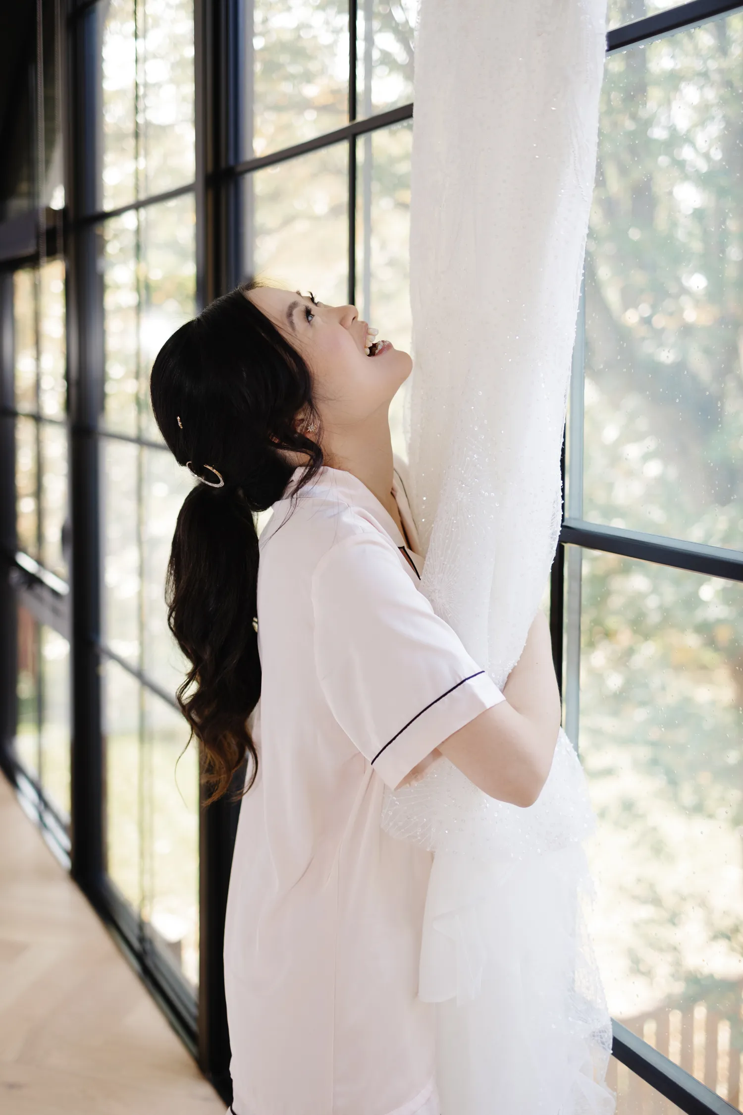 Bride admiring hanging wedding dress