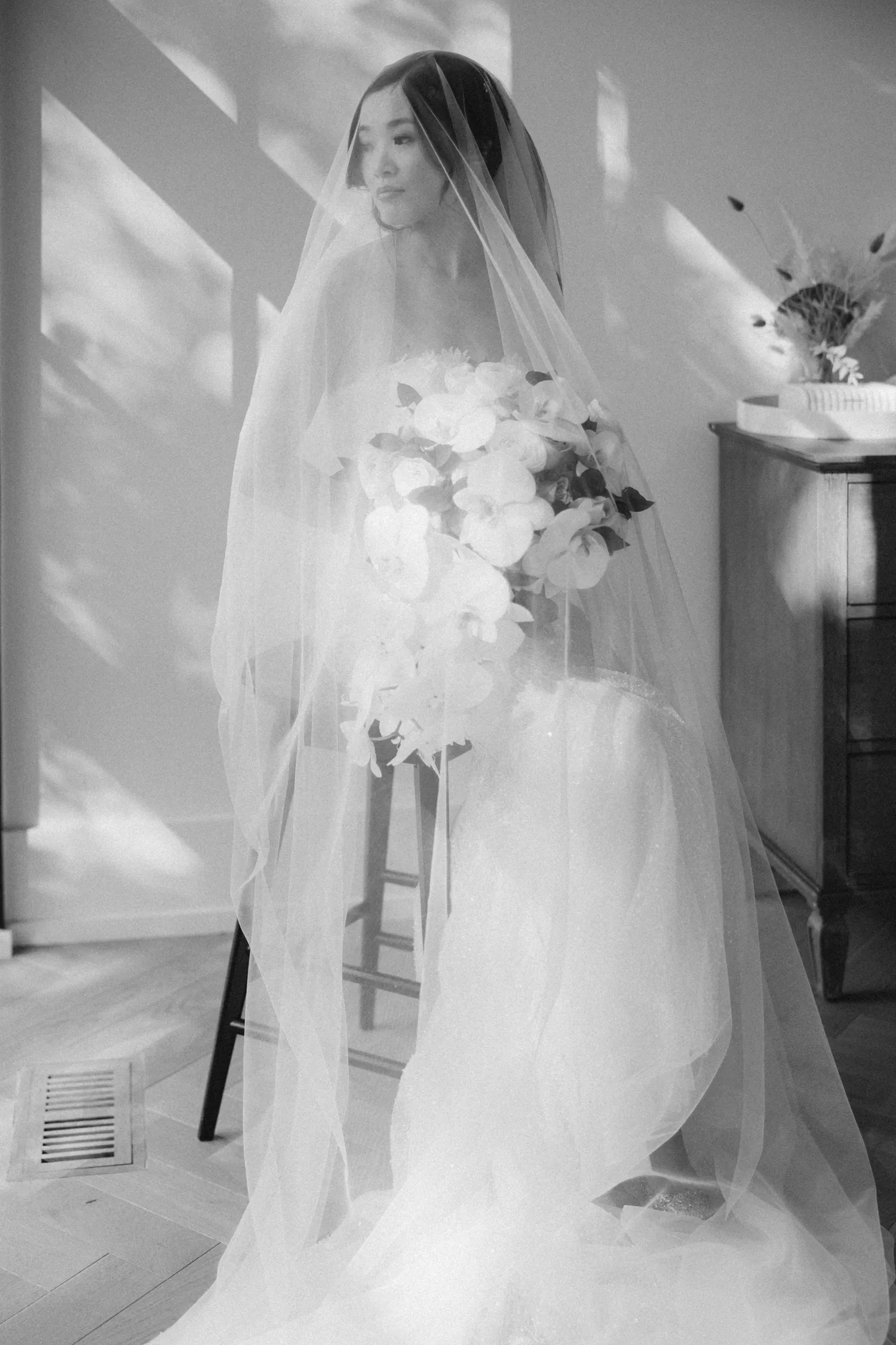 Bride under veil holding bouquet