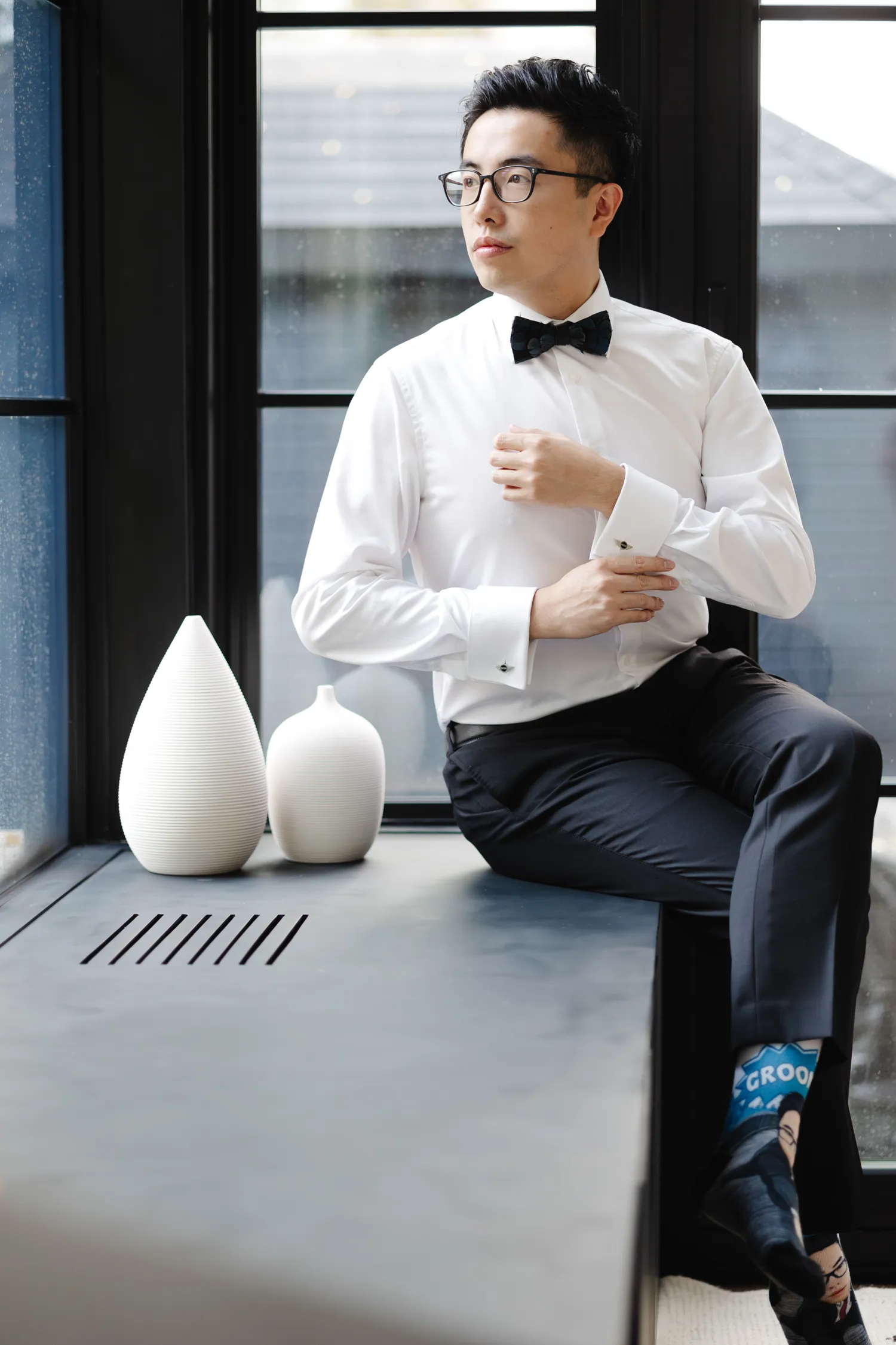 Groom getting ready near window