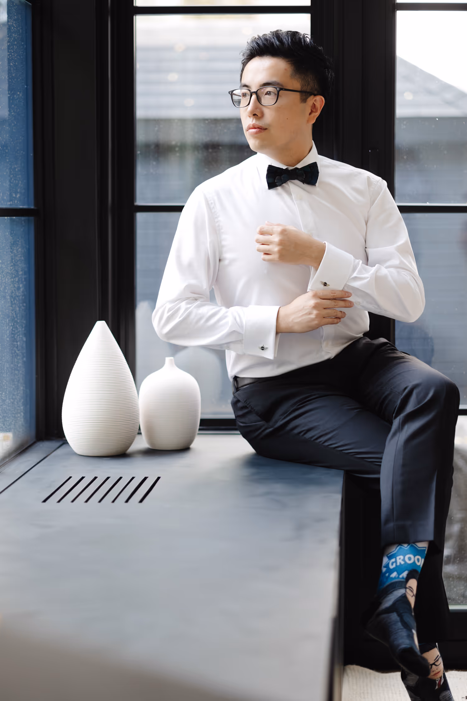 Groom getting ready near window